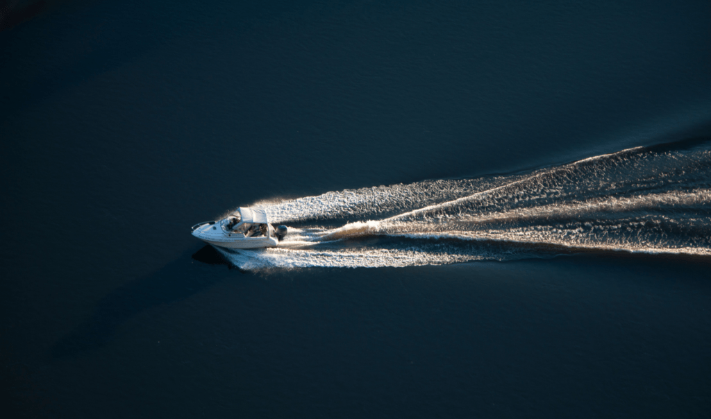 Recreational boating in the Ocean. In the image, a speedboat cuts across Ocean waves leaving a trail in its wake.