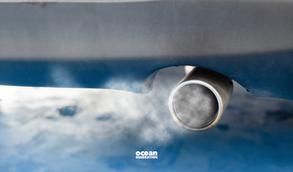 Car exhaust pipe with smoke coming out. Shared by Ocean Generation in a article about actions to reduce carbon emissions.