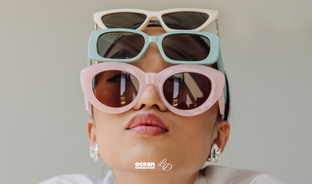 Women wearing three pairs of sunglasses on her head: One pink, blue and yellow. A tranisiton to slow fashion is needed to safegaurd our planet. This article explores greenwashing red flags.